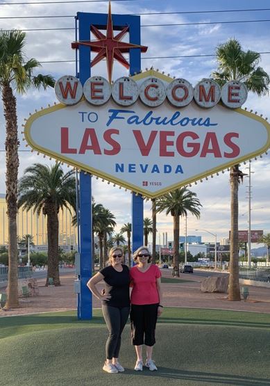 Morgan and her mom Standing in front of the Welcome to Las Vegas sign