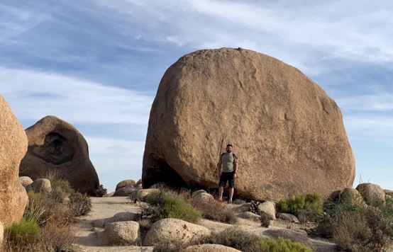Morgan's husband standing in front of a big rock