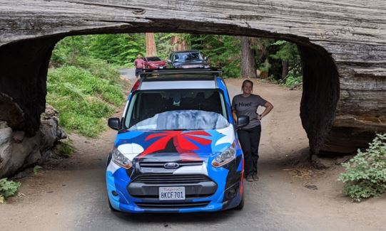 Morgan with the van under a carved out tree