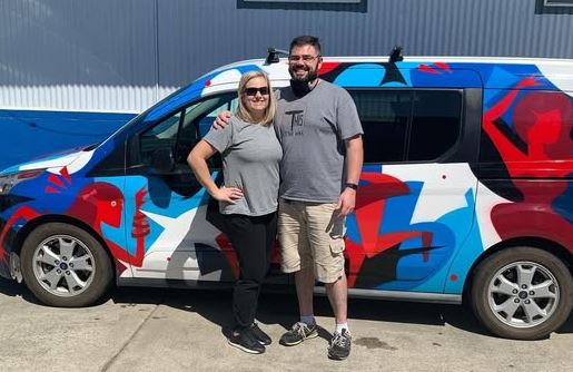 Morgan with her husband standing in front of a van